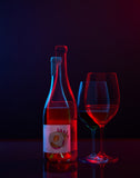 Bottle and glass of wine with a dark background